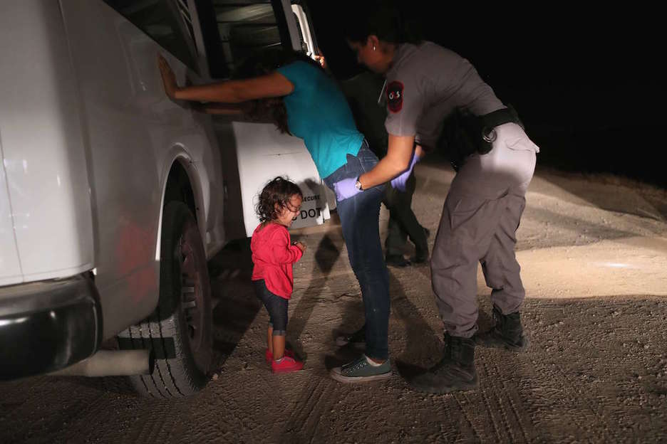 La Policía estadounidense registra a una mujer hondureña, con su hija delante. (John MOORE / AFP)