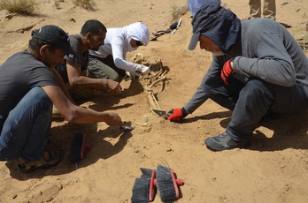 Los miembros del equipo de investigación, con Paco Etxeberria, exhuman uno de los cuerpos en el Sahara. (UPV/EHU)