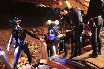 Un grupo de buzos en la cueva en la que quedaron atrapados doce menores y su monitor. (AFP)
