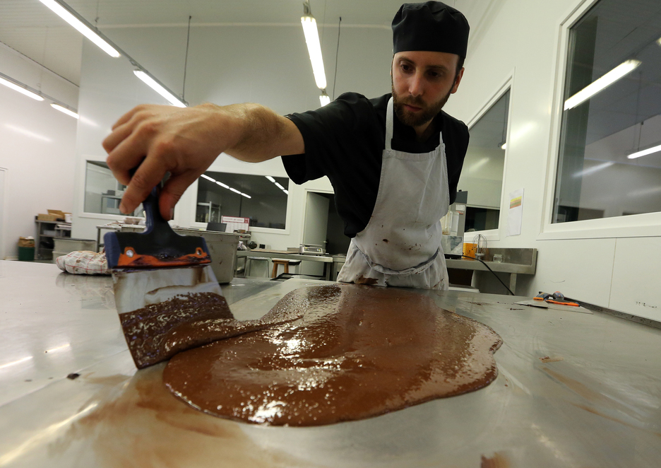 Le chocolatier doit tempérer le chocolat avant de pouvoir le mouler. © Bob EDME