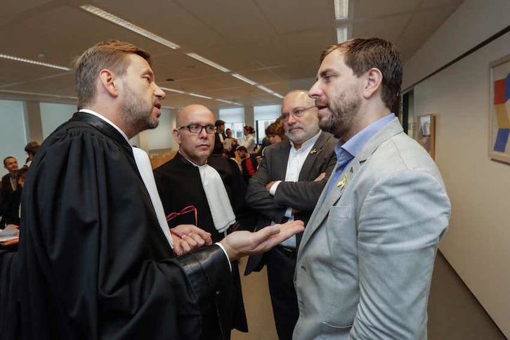 Los exconsellers Lluis Puig y Toni Comin charlan con los abogados Christophe Marchand y Gonzalo Boye. (THIERRY ROGE / AFP)