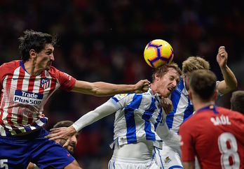 Pugna entre jugadores de la Real y el Atlético. (Óscar DEL POZO/AFP)