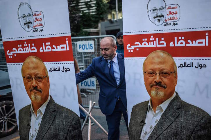 Un hombre coloca fotografías de Jamall Khashoggi en el exterior del consulado de Arabia Saudí en Estambul. (Bulent KILIC/AFP)