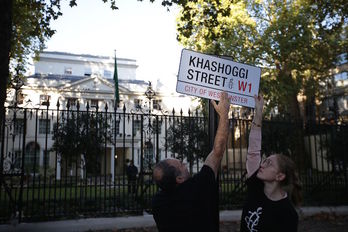 Dos activistas de Amnistía Internacional colocan una placa ante la embajada saudí en Londres. ( DANIEL LEAL-OLIVAS / AFP)