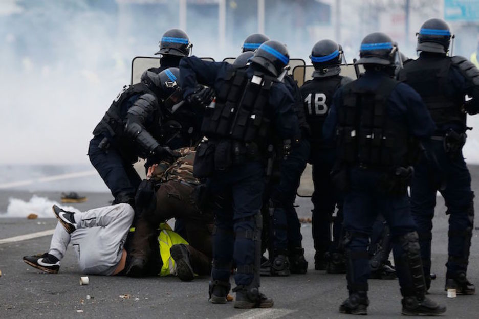 Policías reducen a varias personas en Mondeville, en Calvados. (CHARLY TRIBALLEAU / AFP)