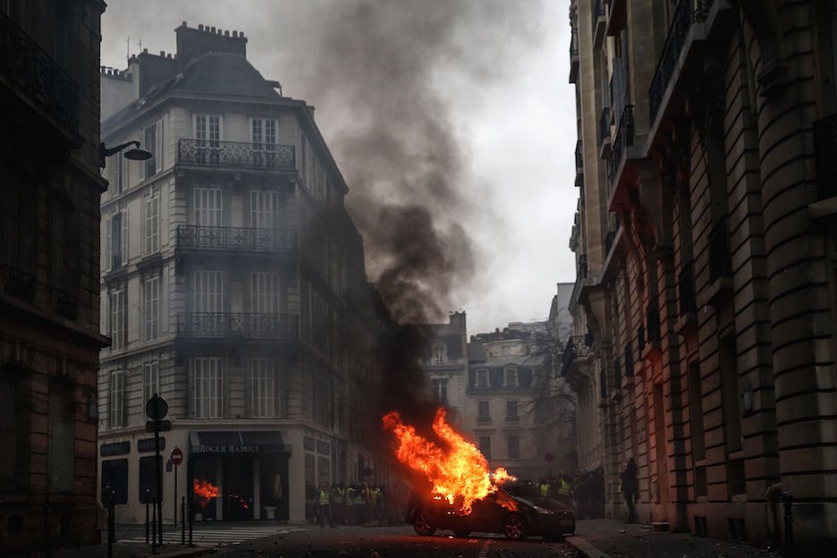 Un coche quemado en una calle de París. (ABDUL ABEISSA / AFP)