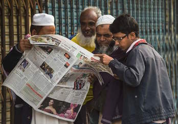 Varias personas consultan los resultados electorales en la prensa. (Indranil MUKHERJEE/AFP)