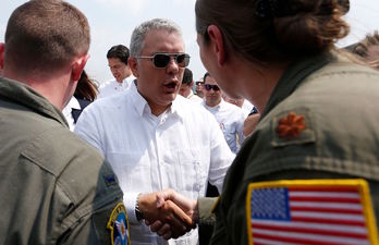  El presidente colombiano Ivan Duque saluda al personal militar estadounidense encargado de transportar a Cucuta provisiones para la denominada «ayuda humanitaria». (Rhona WISE / AFP) 