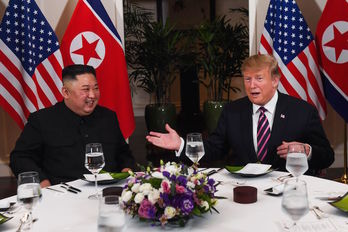 Kim Jong-un y Donald Trump, sonrientes sentados a la mesa. (Saul LOEB / AFP) 