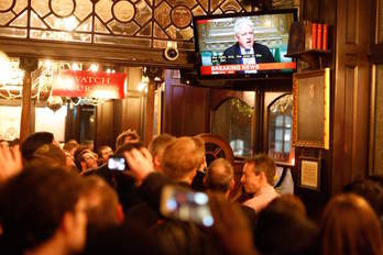 Los clientes de un pub siguen por televisión el resultado de la votación. (TOLGA AKMEN / AFP)
