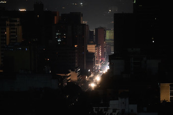 Barrio de Chacaco iluminado por los vehículos durante el apagón. (Federico PARRA/AFP)