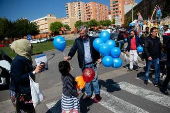 Una niña recoge globos de PP, Ciudadanos y el PSOE para jigar. (Josep LAGO/AFP)