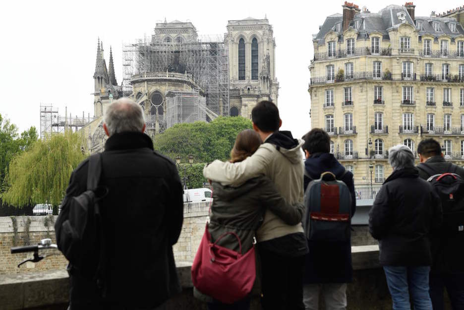 Vecinos y turistas contemplan las consecuencias del incendio. (Bertrand GUAY / AFP)