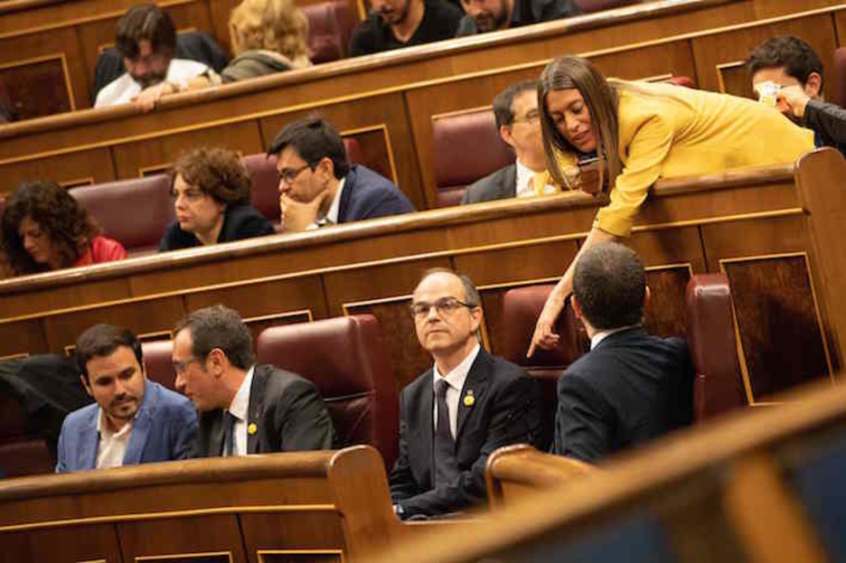 Alberto Garzón charla con Josep Rull, sentado junto a Jordi Turull y Jordi Sànchez. (Bernat ARMANGUE/AFP)