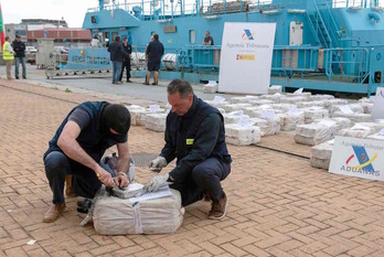 Policías de aduanas inspeccionan un paquete de cocaína del pesquero Gure Leire en el puerto de Vigo. (Miguel RIOPA/AFP)