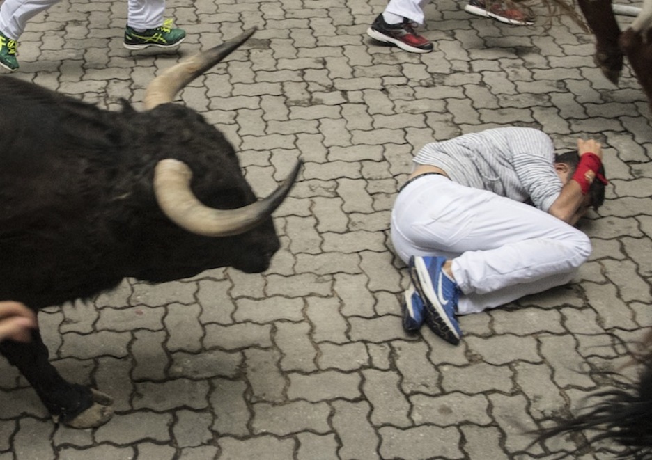Un corredor enseña cómo hay que protegerse ante el toro una vez caído. (Jagoba MANTEROLA | FOKU)