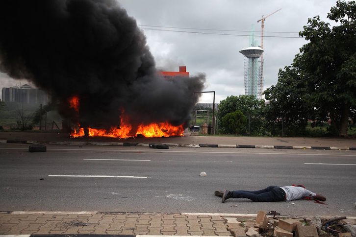 Uno de los manifestantes yace en el suelo tras haber sido disparado. (KOLA SULAIMON /AFP)