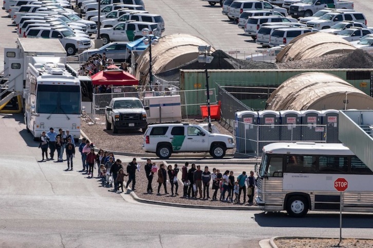 Solicitantes de asilo esperan para subir a los autobuses que les llebarán a los albergues en El Paso. (Paul RATJE / AFP)