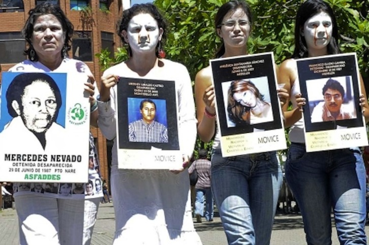 Activistas y familiares muestran fotografías de desaparecidos. (AFP)