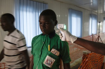 Un oficial sanitario controla la temperatura a un estudiante en una escuela la localidad congoleá de Mpondwe, fronteriza con Uganda. (Isaac KASAMAMI/AFP PHOTO)