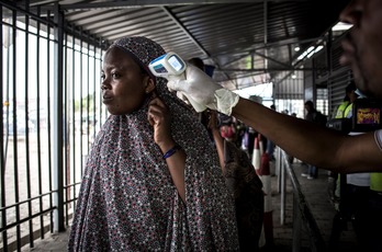 Toman la temperatura a una mujer en un centro de detección del ébola. (John WESSELS / AFP)