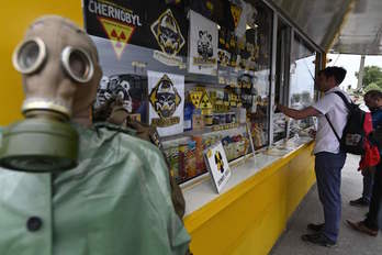 Un turista compra recuerdos en un puesto de control del radio del 30 kilómetros en torno a la central nuclear de Chernóbil. (Genya SAVILOV/AFP)