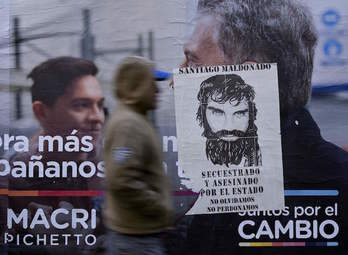 Un cartel electoral de Macri, cubierto por otro que recuerda a Santiago Maldonado. (Juan MABROMATA/AFP)