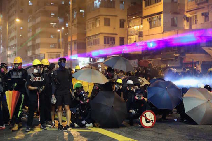 Manifestantes forman una línea ante las fuerzas policiales. (May JAMES / AFP) 