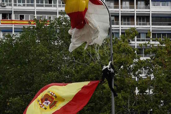 El paracaidista ha quedado colgado de una farola. (Óscar DEL POZO/AFP)