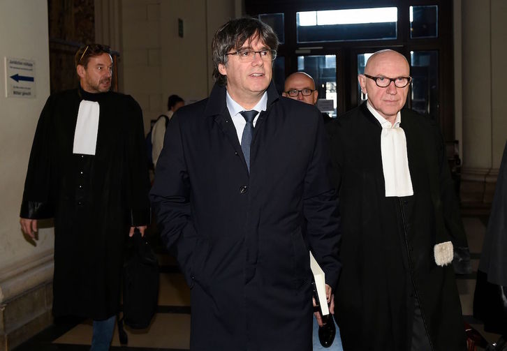 Puigdemont, junto a sus abogados, a la llegada al juzgado de Bruselas. (John THYS / AFP)