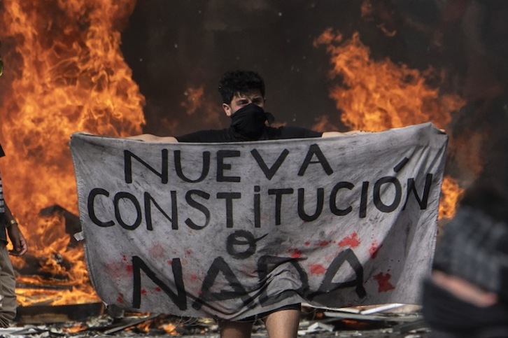 Un joven reclama una «nueva Constitución o nada» durante una protesta en Santiago de Chile, el pasado día 22. (Pedro UGARTE/AFP)