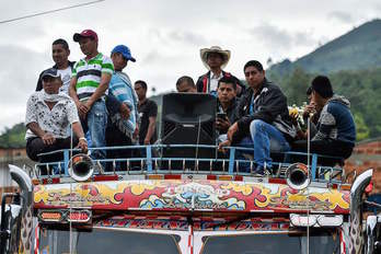 Indígenas a bordo de un autobús acuden a los funerales de una de las víctimas. (Luis ROBAYO/AFP)