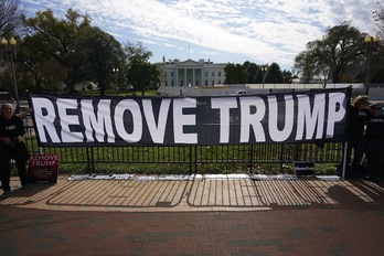 Activistas colocan una pancarta a favor de la destitución de Trum ante la Casa Blanca. (Mandel NGAN/AFP)