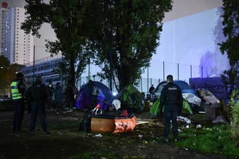 Policías franceses desmontan un campamento de refugiados en París. (Martin BUREAU / AFP)