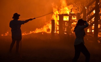 Los residentes defienden una propiedad de un fuego forestal en Hillsville, a 350 km al norte de Sidney. (Peter PARKS | AFP)
