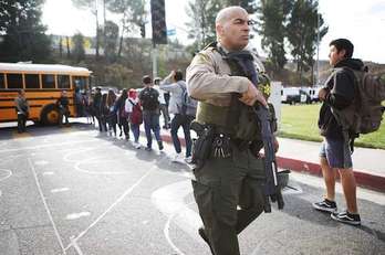 Un agente custodia a los estudiantes en Santa Clarita. (Mario TAMA/AFP)