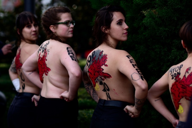 Activistas de Femen mostrando el mensaje «Stop 20N» en sus espaldas. (Óscar DEL POZO / AFP)