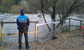 Un policía municipal vigila el caudal del Arga en Iruñea. (@PamplonaIrunaPM)