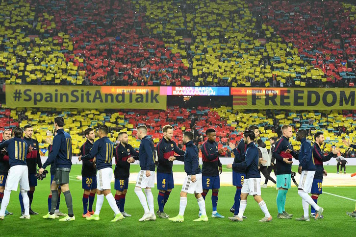 Los jugadores del Real Madrid y del Barça se saludan antes del encuentro. (Lluís GENE/AFP)