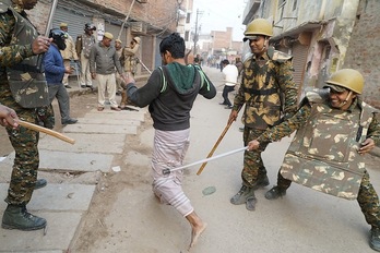 Policías golpean a un manifestante en Varanasi. (AFP)