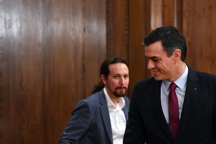 Pedro Sánchez, con Pablo Iglesias detrás al presentar su pacto. (Gabriel BOUYS | AFP)