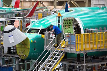 Trabajadores de Boeing revisando un 737 Max (JASON REDMOND|AFP)