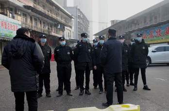 Agentes con mascarillas en las calles de Wuhan.  (Noel CELIS/AFP)