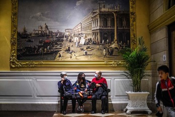 Varias personas se protegen con mascarillas en un hotel de Macao. (Anthony WALLACE / AFP)