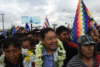 David Choquehuanca (i) recibe a Luis Arce (c) en el aeropuerto del Alto. ( Aizar RALDES / AFP)