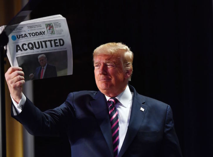 Donald Trump exhibe un diario con el titular «Absuelto». (Nicholas KAMM/AFP)