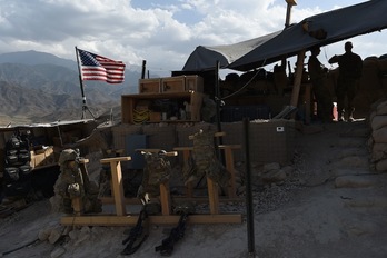 Soldados estadounidense miran cómo ondea su bandera en un puesto de control en Deh Bala, en Nangarhar. (Wakil KOSHAR / AFP)