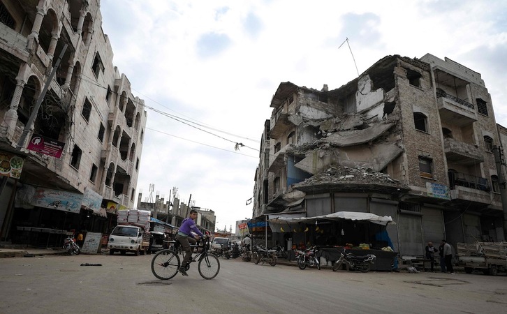  Un joven circula en bicicleta entre edificios bimbardeados en Idleb.(Omar HAJ KADOUR/AFP) 