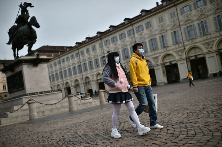 Dos turistas asiáticos con mascarillas pasean por una desierta plaza de San Carlo en Turín     (Marco BERTORELLO  I FOKU)