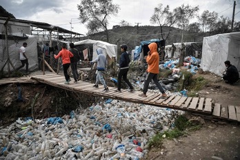 Varios niños cruzan un «puente» en el campo de refugiados de Moria, en Lsbos. (Louisa GOULIAMAKI / AFP)